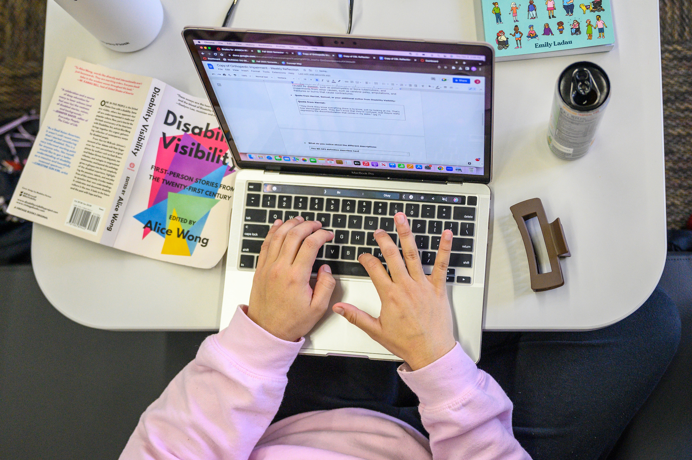 overhead image of person typing with a book