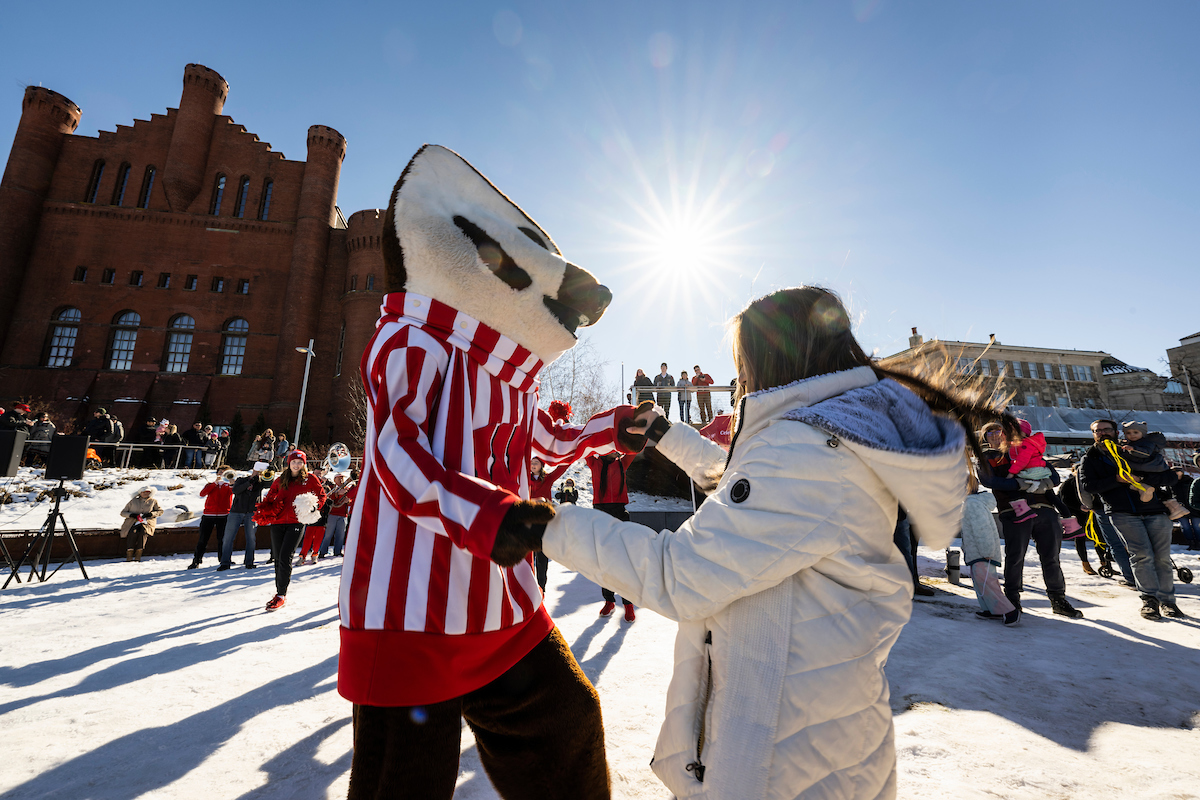 woman in white coat dancing with bucky at winterfest