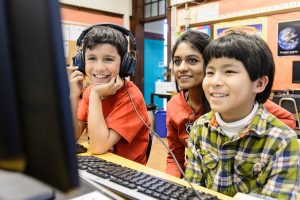student working with two children at a computer
