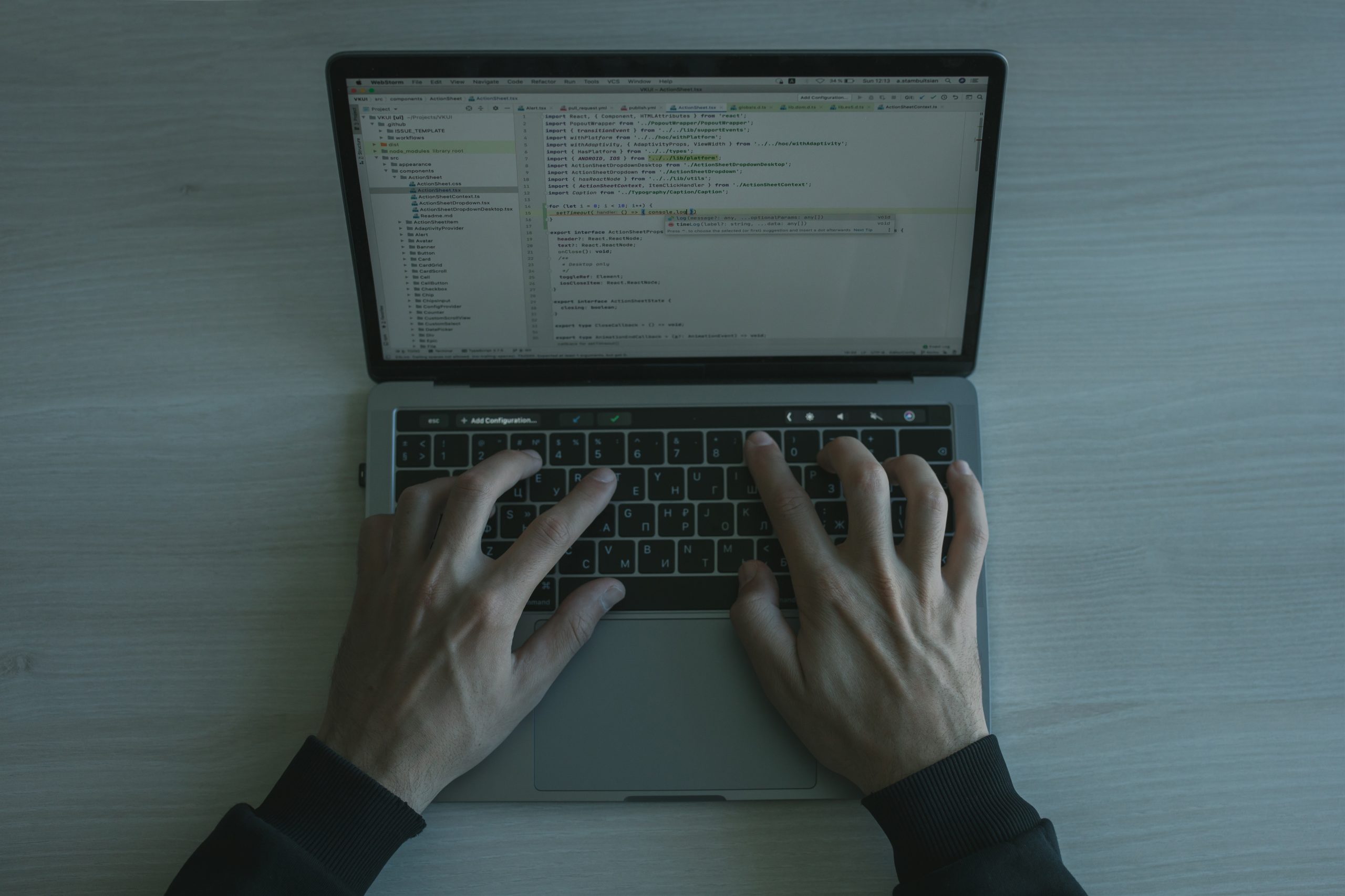 Hands typing on a laptop