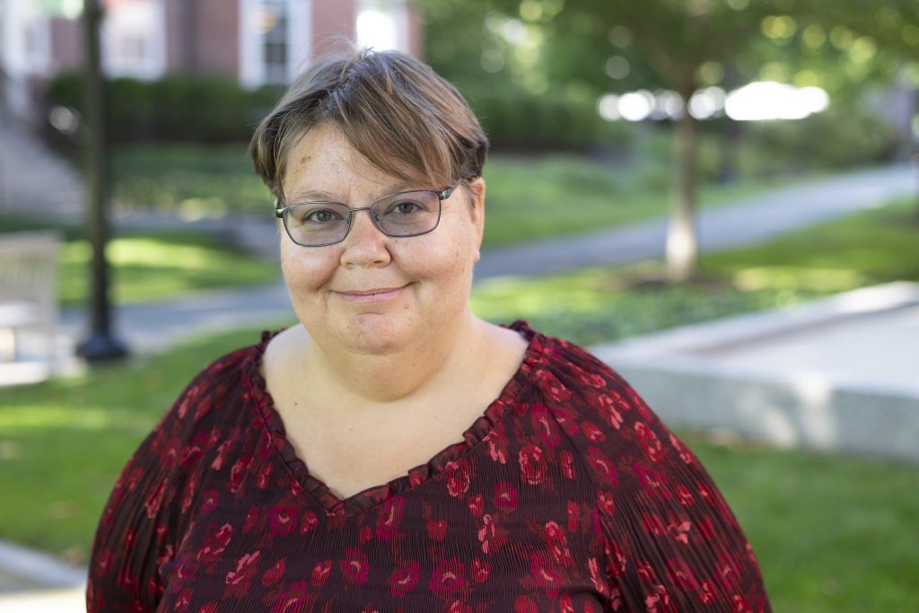 Woman in red and black shirt, outdoor college campus background