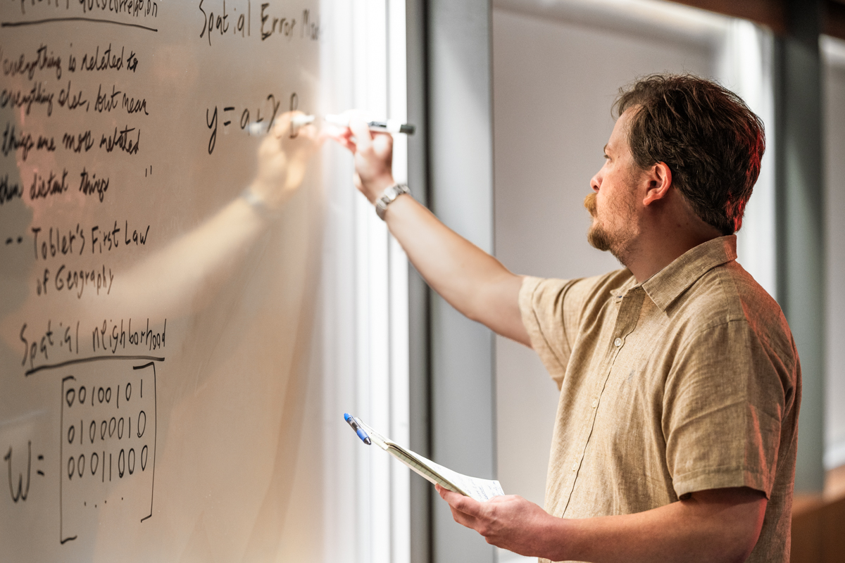 Professor writing on whiteboard