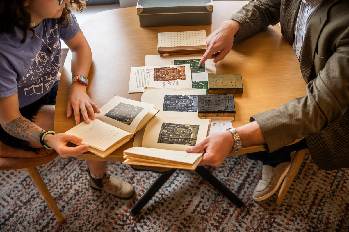 Books laid out with two people at table