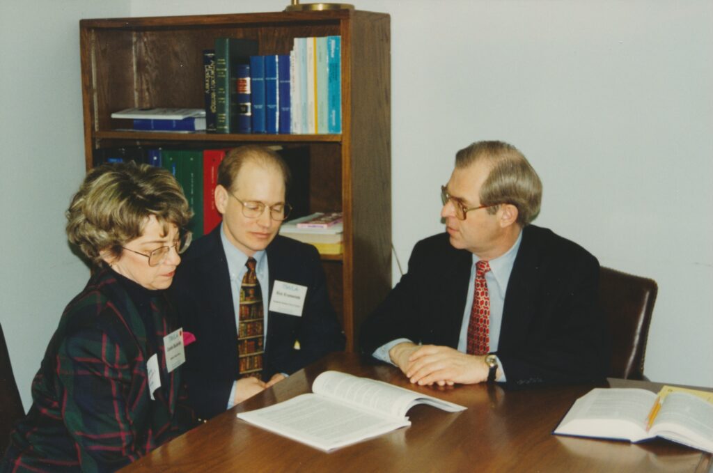 People talking at a table with a book open
