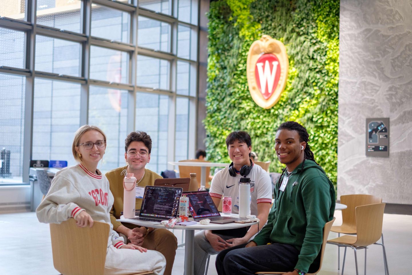 Four students at a table smiling